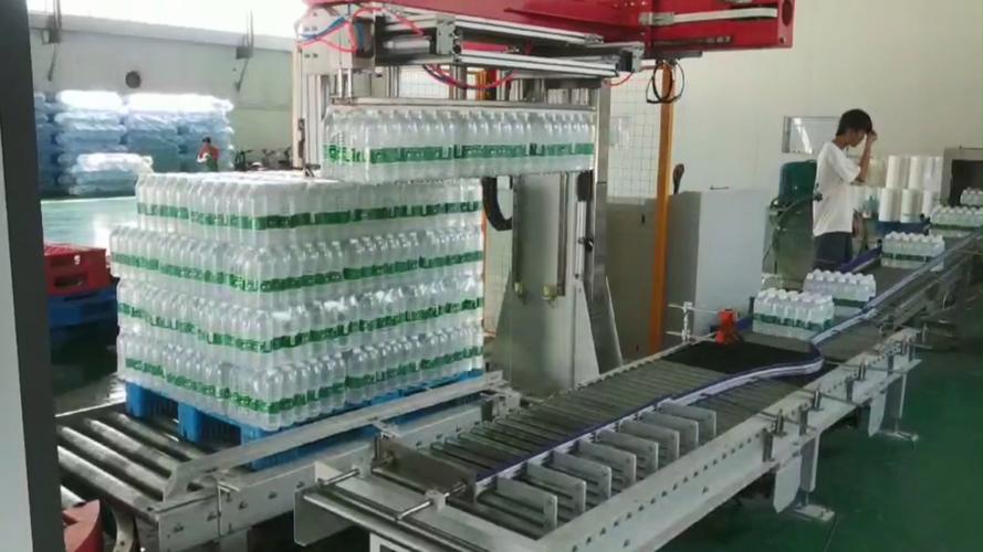 瓶装水厂整箱成品码垛机械手作业现场图