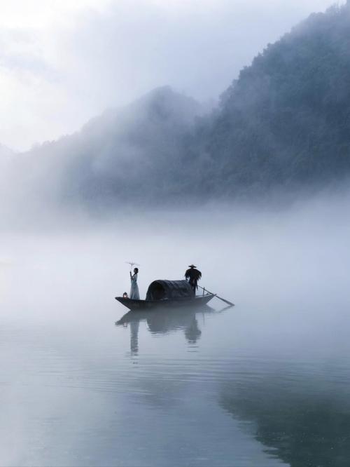 江边潮湿雾气中散步人物实景图
