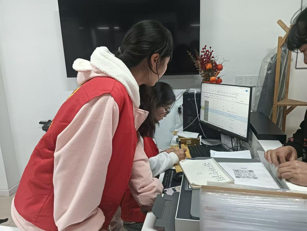 大学生村官用电脑整理村民档案