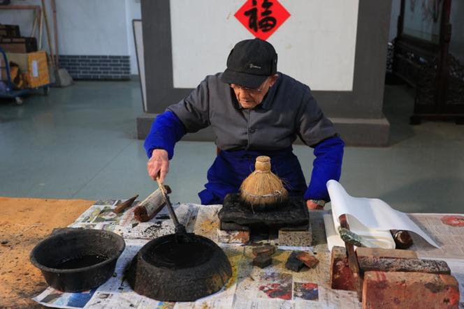 朱仙镇老艺人郭泰运持棕耙印木版年画工序特写