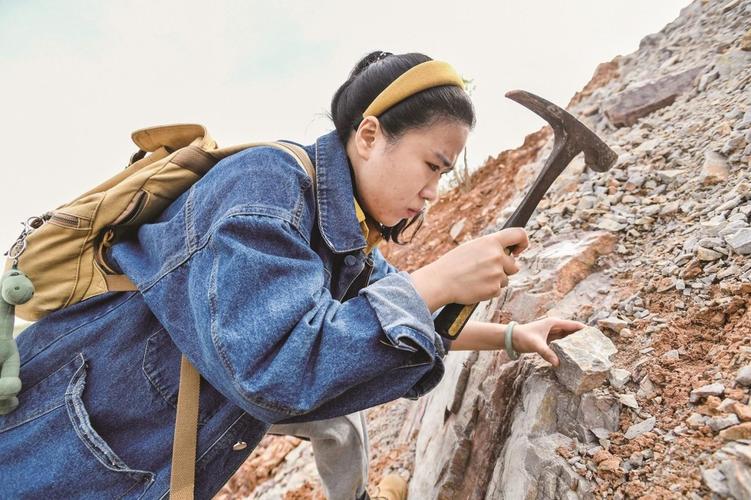 化石猎人手握锤子敲打岩层发现化石