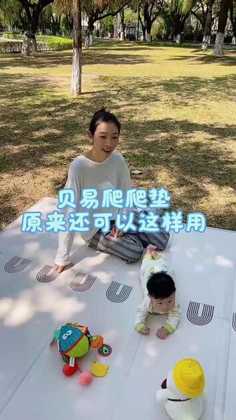 8个月宝宝趴在爬爬垫上摸装半瓶大米的矿泉水瓶