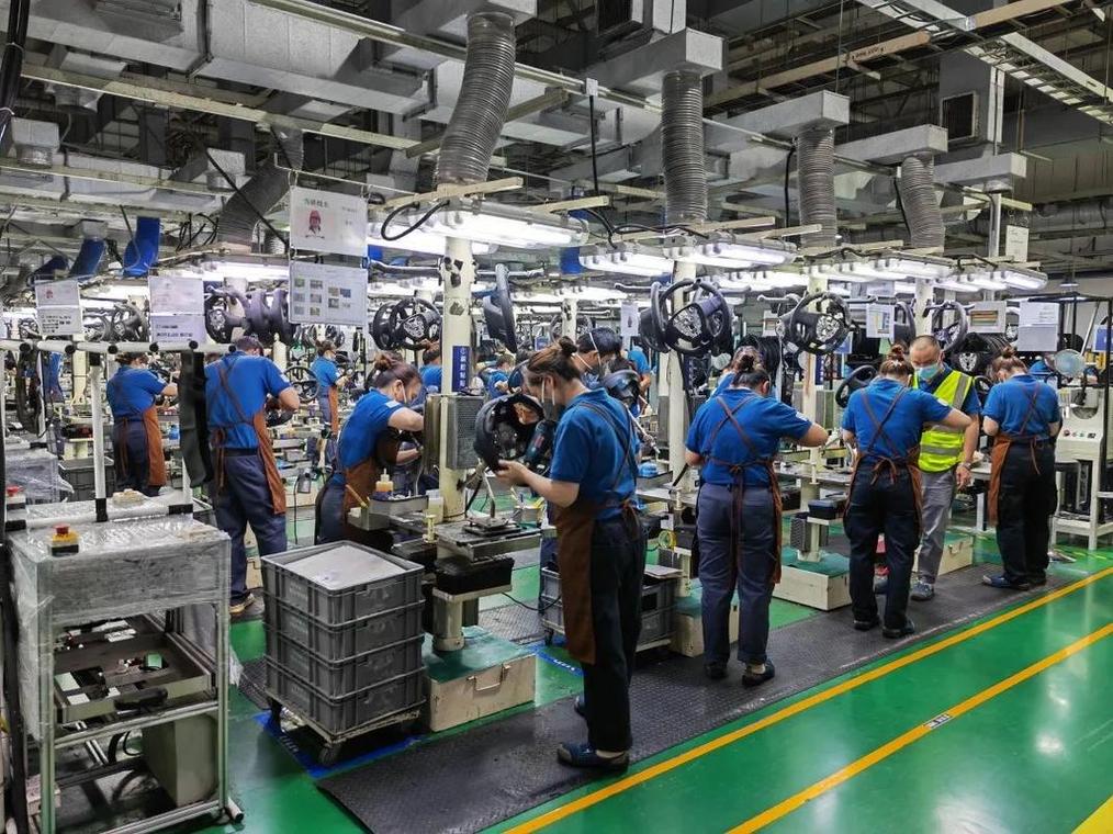 汽配厂流水线工人休息间隙集体大笑场景