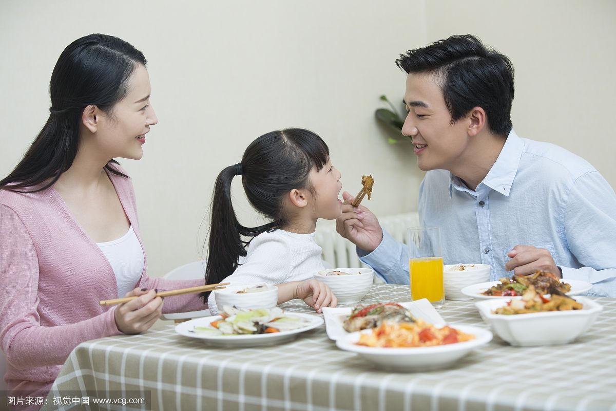 晚饭桌边一家三口玩词语升级游戏的日常抓拍