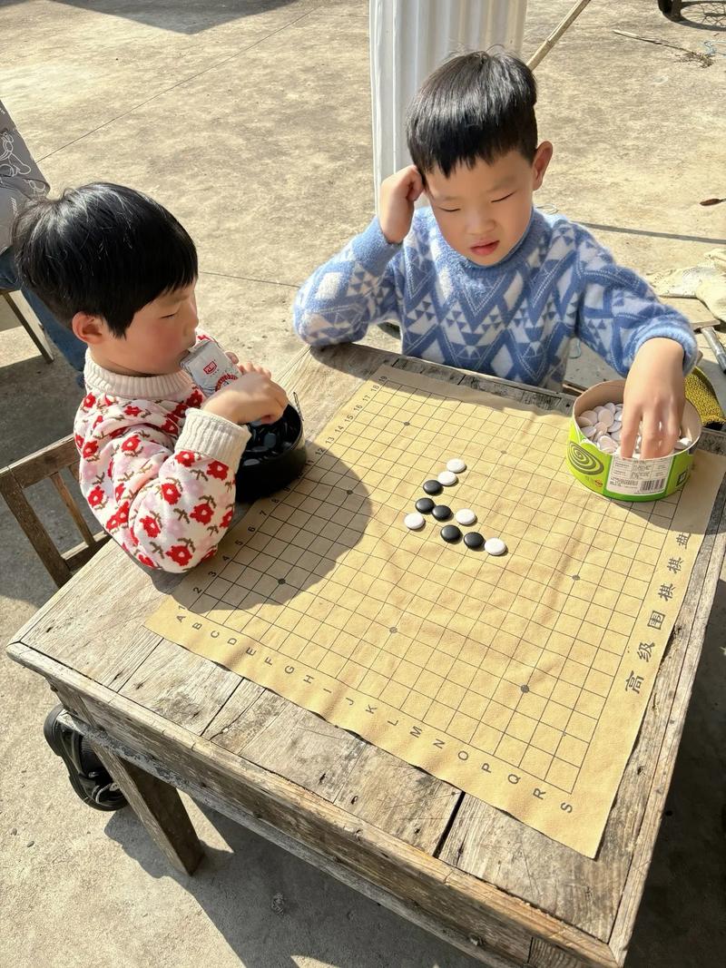 小朋友趴在地板上下五子棋的日常场景