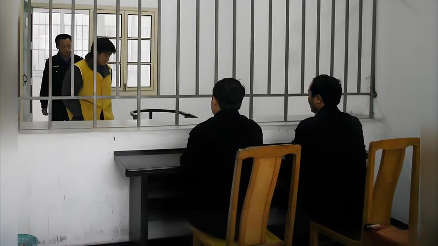 律师在看守所拥挤的会见室与当事人隔窗交谈的场景