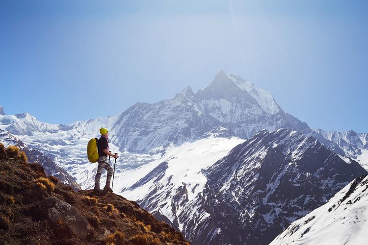 孩子站在山脚仰望山顶,手里拿着等高线地形图