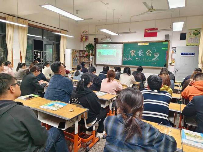 小学教室家长会家长低头在笔记本上记重点的背影