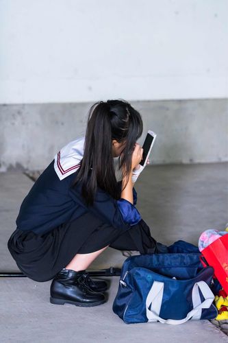 中学生校园角落女生蹲坐发呆场景