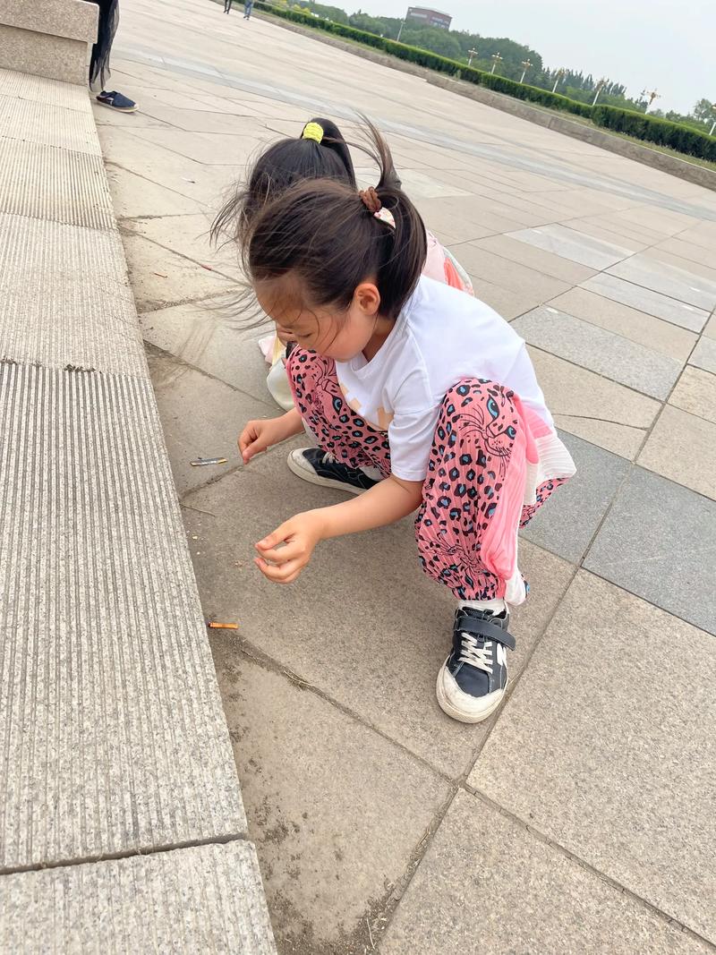 儿童蹲路边观察蚂蚁的真实亲子场景