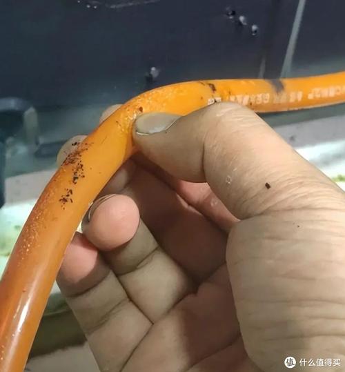 手捏老化橡胶燃气软管表面裂纹特写