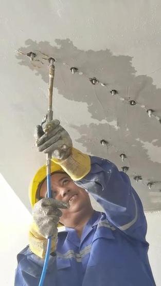 装修师傅使用注浆器修补墙体裂缝