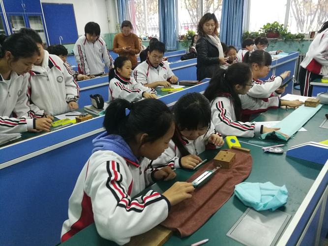 初中物理课上教师带着学生在讲台做摩擦力对比小实验