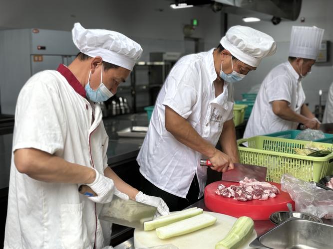 学校食堂后厨工作人员正在烹饪大锅菜