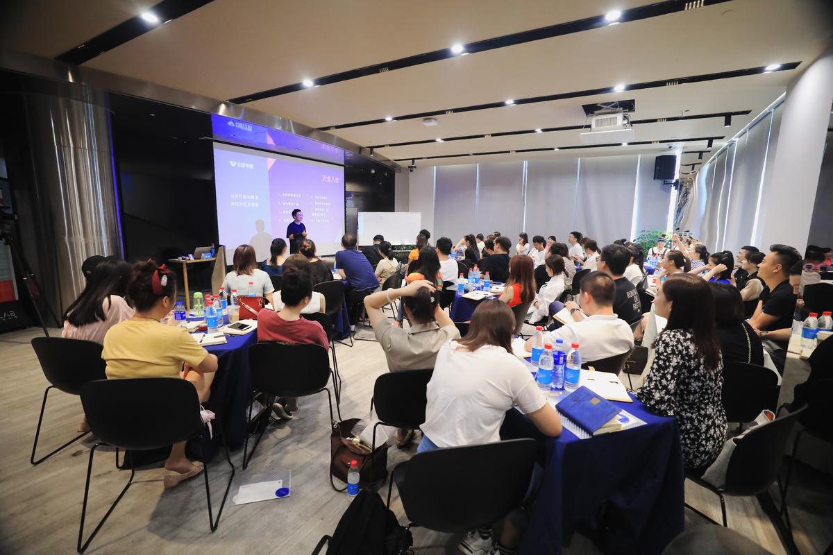 油管MCN机构线下宣讲会现场,台上讲师对着PPT演讲,台下人群簇拥