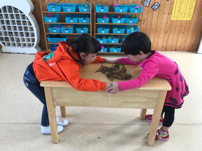 幼儿园孩子坐在书桌前盯着橡皮上的蚂蚁看的真实场景