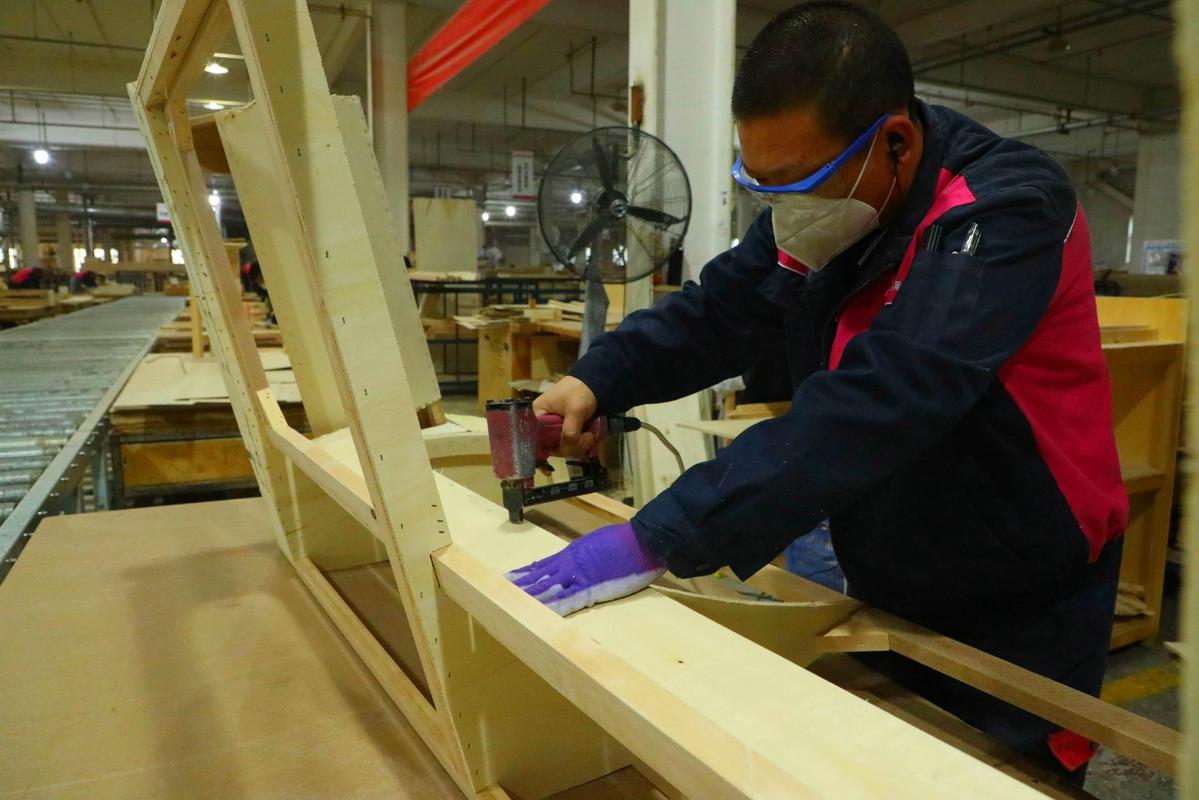 家具厂操作员在安全防护完备的木工机械旁作业