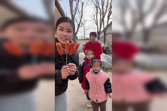妈妈和孩子蹲在小区烤肠摊前数烤肠的亲子互动场景