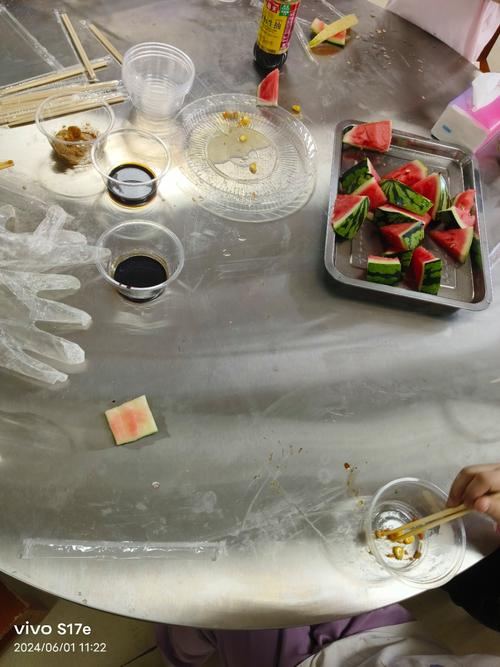 厨房中孩子正在对比两个杯子中酵母发酵产生泡沫的差异,桌上放着面粉和勺子