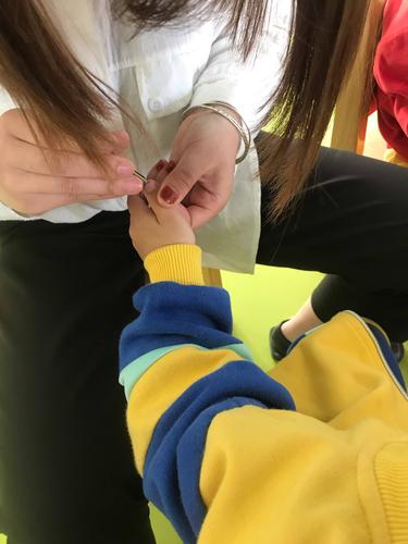 1岁幼儿被大人轻握手腕引导情绪的实拍图