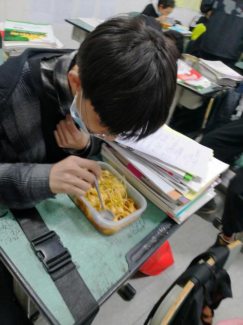 高中教室走廊消防通道里独自吃干脆面的学生
