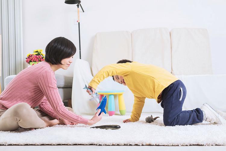 客厅地毯上母子共同制作亲子手工的日常场景