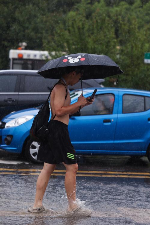 雨天街边卷着裤脚走路的路人