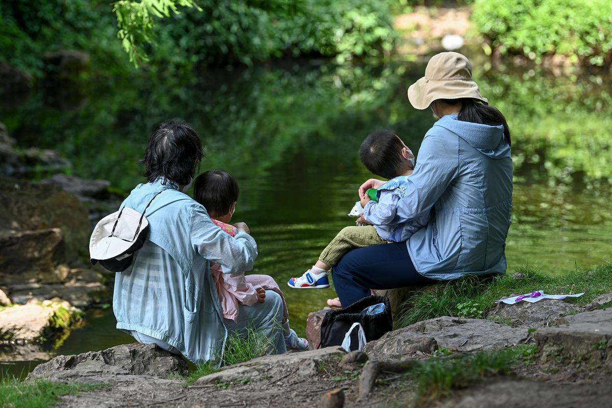 一家人带娃逛公园妈妈留在家休息场景