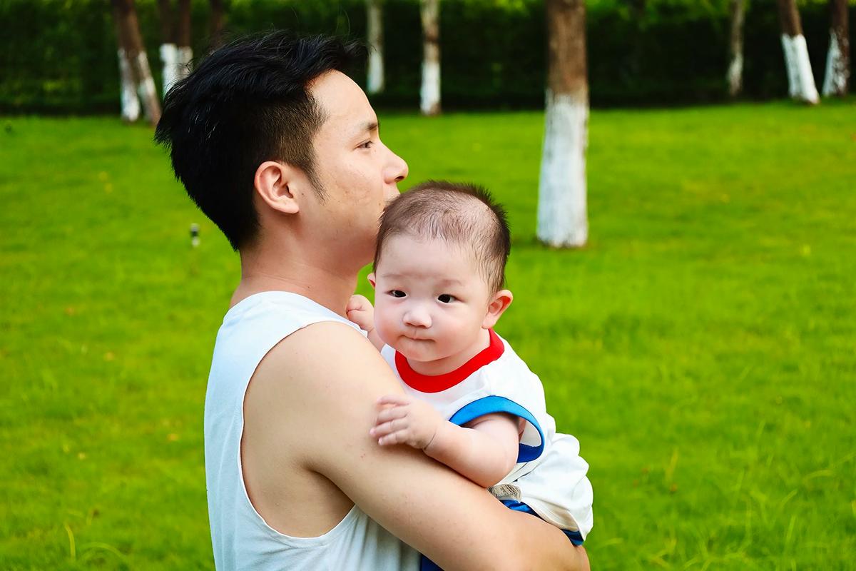 父亲微笑着紧紧拥抱哭泣的幼童