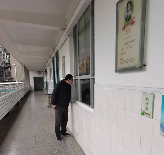 高中走廊晚自修老师靠在后门框观察教室内学生的写实场景