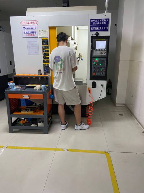 工人在数控钻床前进行编程操作培训
