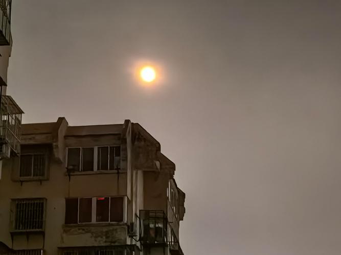 城市上空带月晕的月亮特写