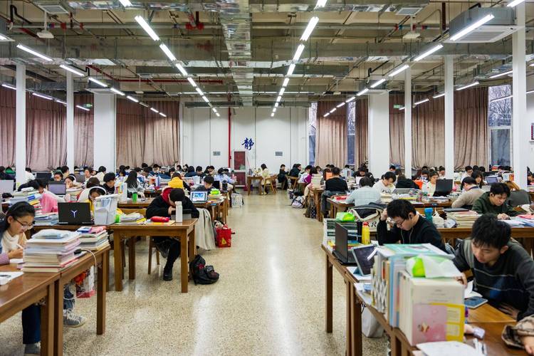 深夜考研自习室堆满书籍的桌面