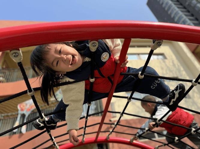 孩子户外运动攀爬架上开心的笑脸