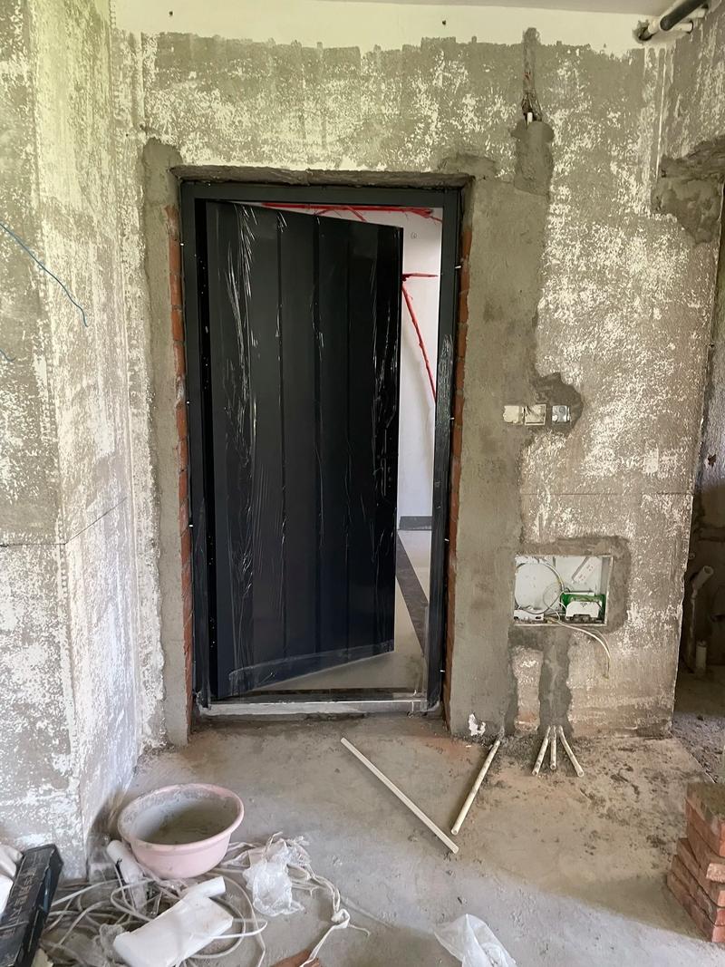防盗门安装工人正在门框内灌入水泥砂浆施工图
