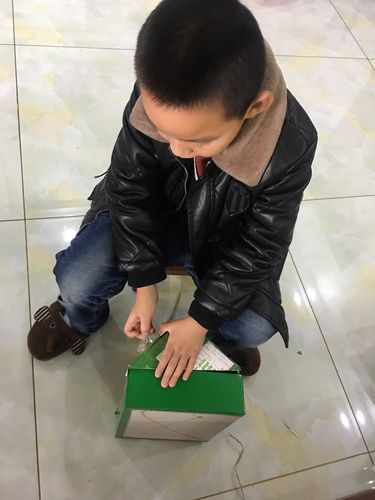 小学走廊里因剪坏手工作品蹲地抹眼泪的三年级男生