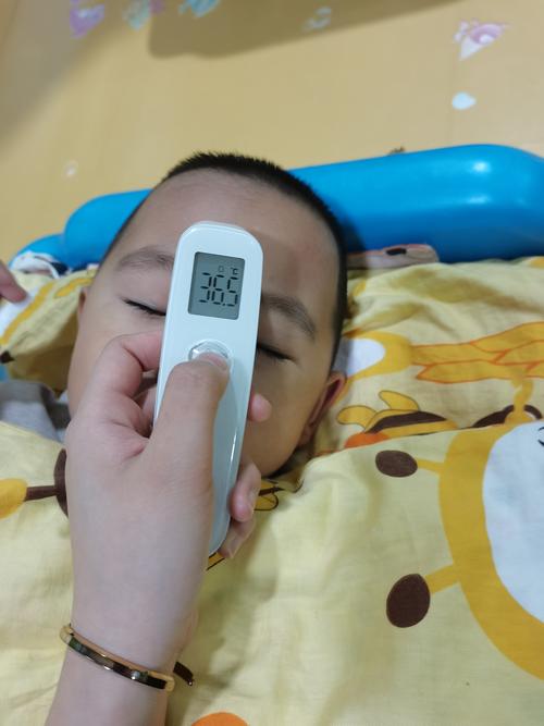 三岁小孩举着测温枪靠在沙发上的居家实拍图