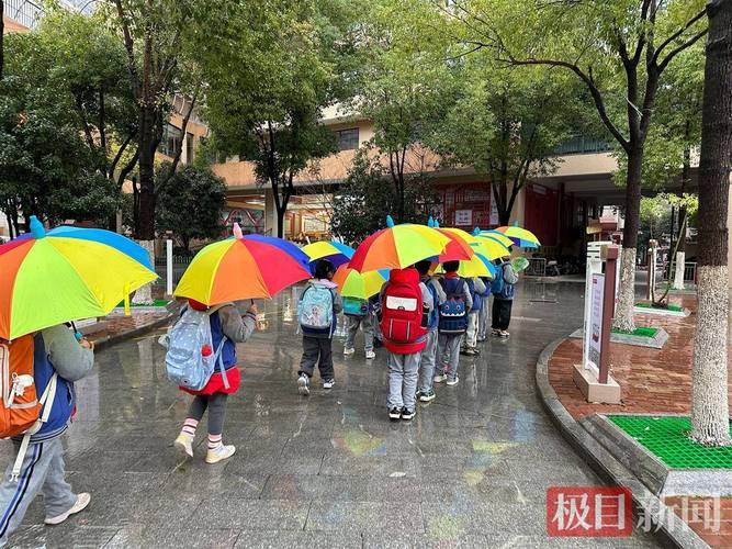 接孩子放学时段校门口家长撑遮阳伞的实拍