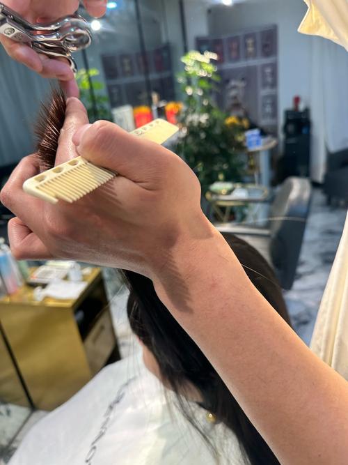 发型师用剪刀进行徒手抓剪发型处理特写