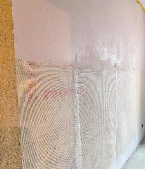 装修师傅在墙角铺设耐碱网格布