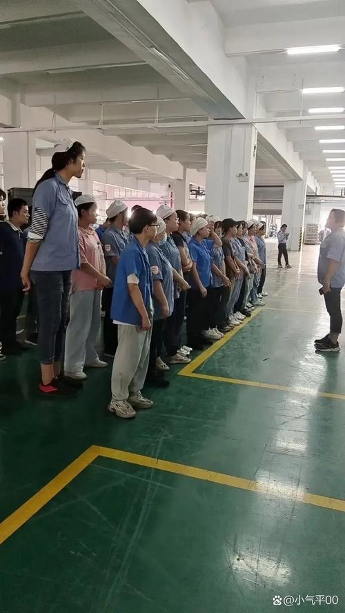 工厂车间里工人围成圈大笑练习