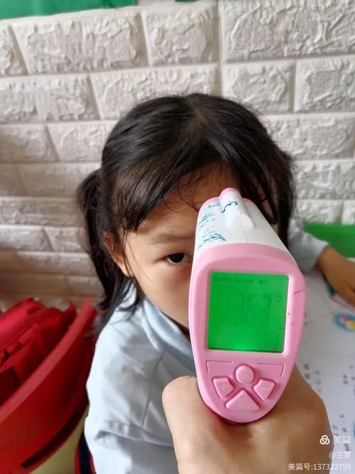 幼儿园小朋友伸手摸户外不锈钢气温计的实拍图