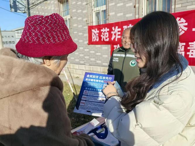 社区普法摊位上居民围听反诈讲解的现场照片