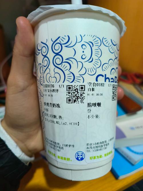 一杯茶百道铁观音奶冻的特写，旁边有点单小票