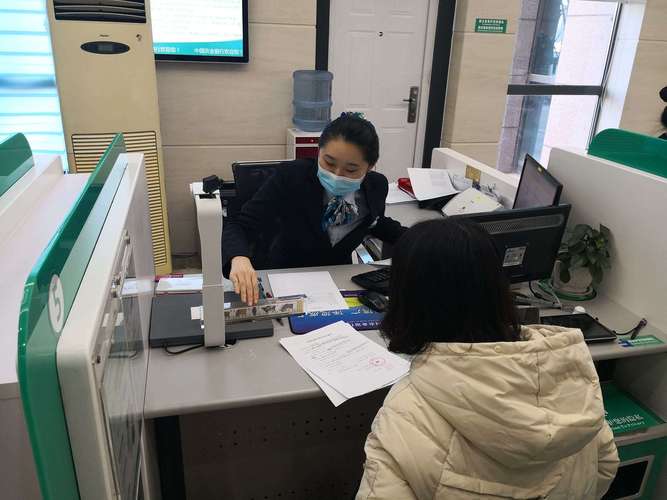 银行房贷柜台办理共同还款人签字场景