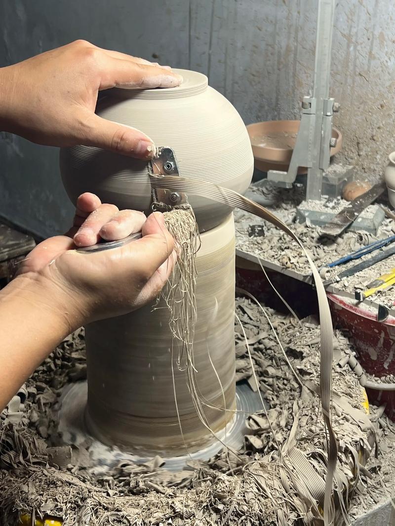 陶艺拉坯过程中双手与潮湿泥土的特写