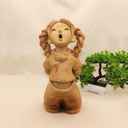 家中茶几上未完工的泥塑人物局部作品