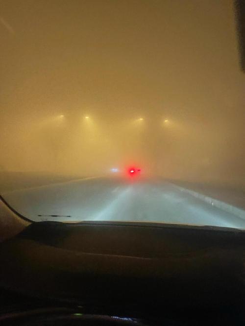 高原山路大雾中的车辆灯光