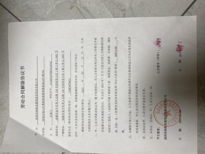 刚毕业的求职者坐在出租屋桌前翻看劳动合同