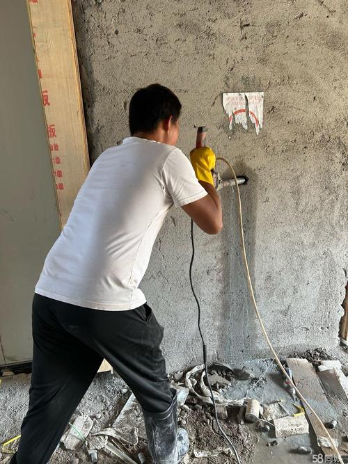 家装工人现场使用手持锂电钻打混凝土孔场景